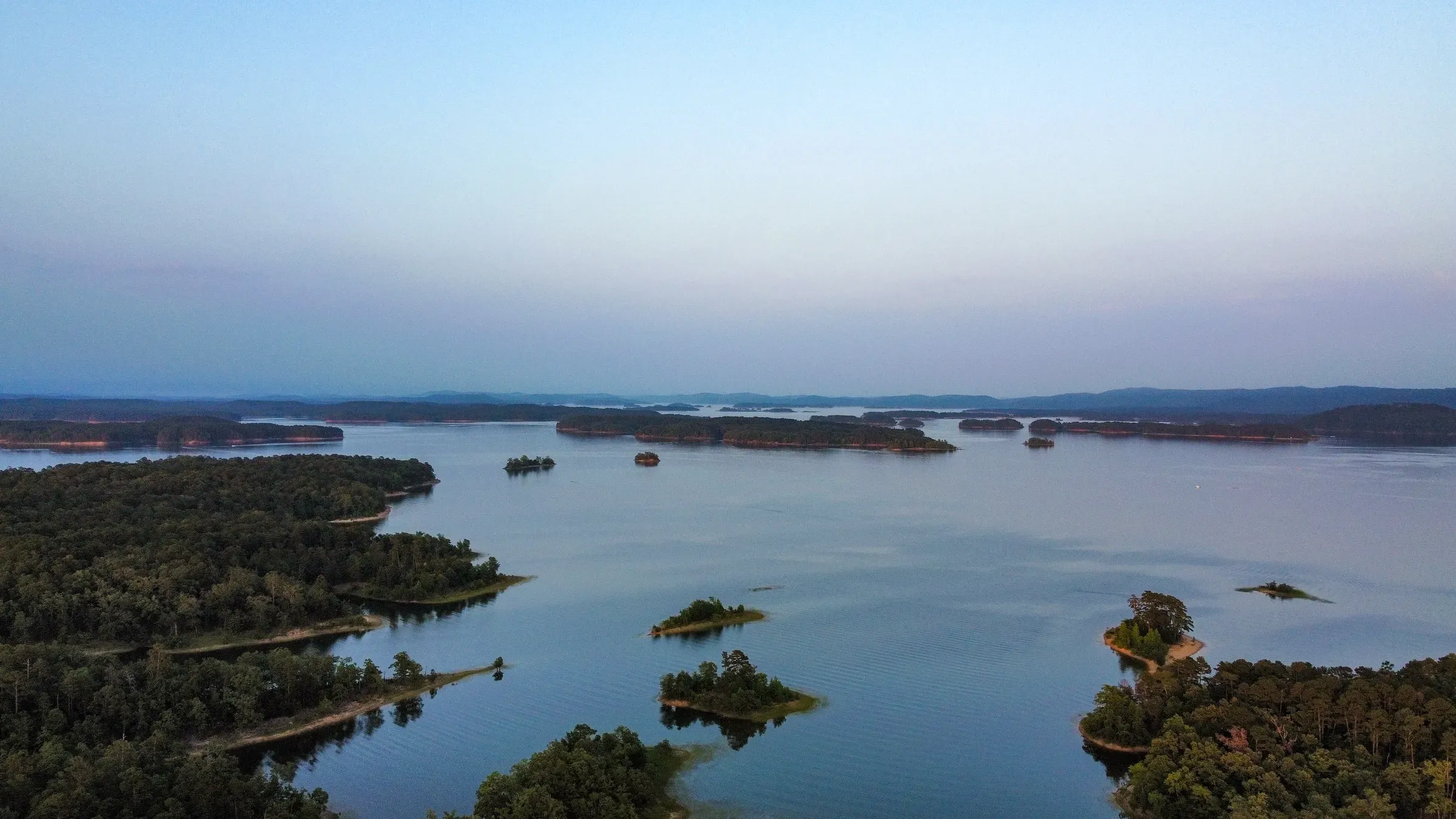 Lake Ouachita at blue hour, with wooded islands scattered across calm water