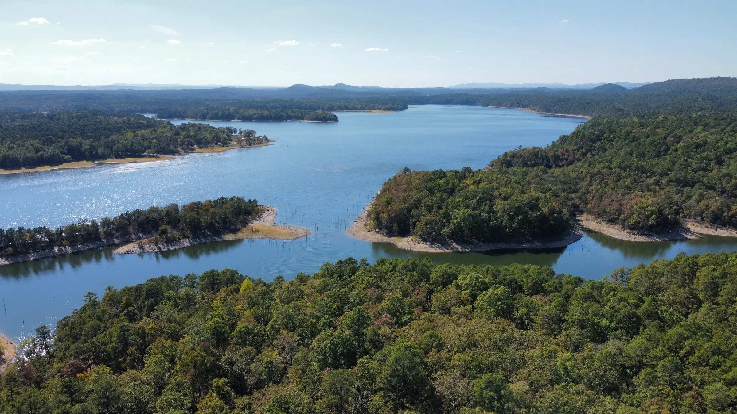Aerial view of Lake Ouachita's coves and wooded shoreline on a sunny day