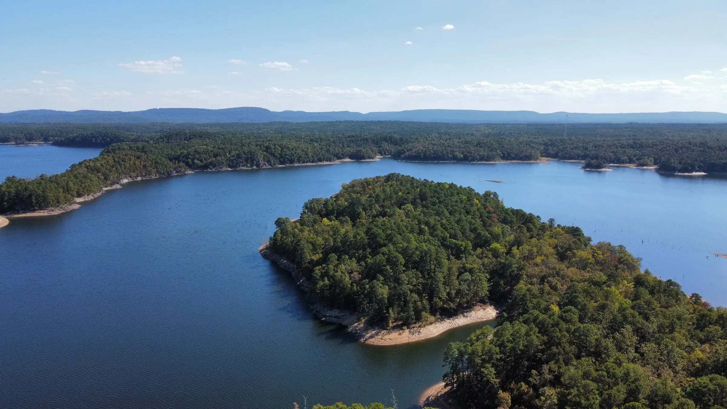 Aerial view of a forested island on Lake Ouachita on a clear day